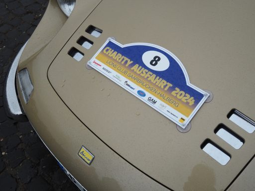 Goldfarbener Rennwagen mit einer Aufklebernummer 8 und Eventbezeichnung.